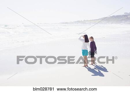 Caucasian girls standing on bright beach View Large Photo Image Stock Image - Caucasian girls standing on bright beach. Fotosearch