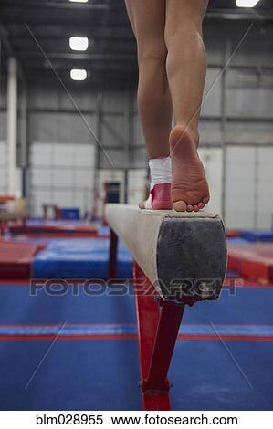 Stock Photography - Caucasian gymnast practicing on high beam. Fotosearch