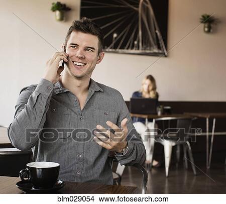 Caucasian man talking on cell phone in cafe View Large Photo Image Picture - Caucasian man talking on cell phone in cafe. Fotosearch