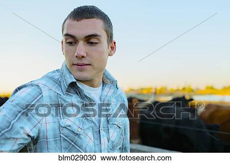 Stock Image - Caucasian man working on farm. Fotosearch
