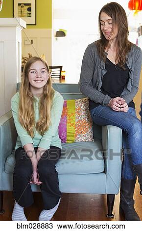 Caucasian mother and daughter smiling in living room View Large Photo Image Stock Image - Caucasian mother and daughter smiling in living room. Fotosearch