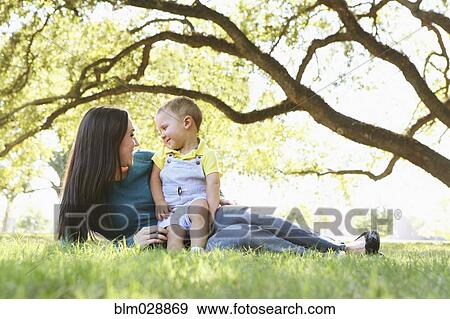 Caucasian mother and son relaxing in park View Large Photo Image Stock Photo - Caucasian mother and son relaxing in park. Fotosearch