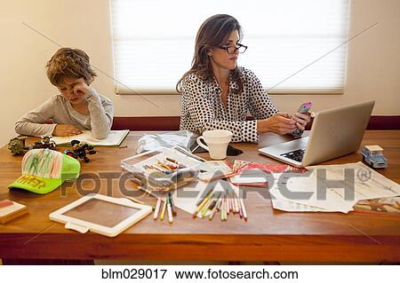 Caucasian mother and son working at table View Large Photo Image Stock Photo - Caucasian mother and son working at table. Fotosearch
