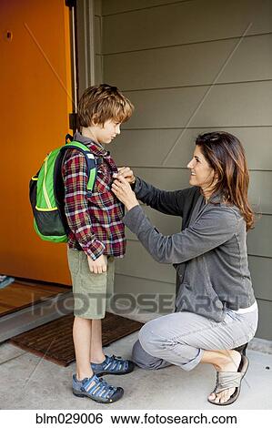 Caucasian mother buttoning son's shirt View Large Photo Image Stock Photograph - Caucasian mother buttoning son's shirt. Fotosearch