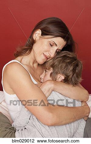 Stock Image - Caucasian mother hugging son. Fotosearch
