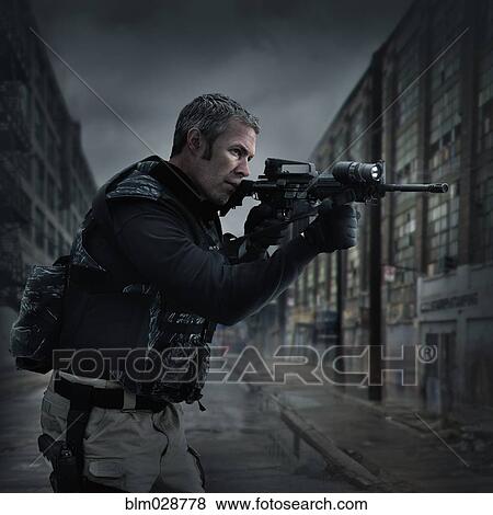 Stock Photo - Caucasian sniper aiming gun on city street. Fotosearch