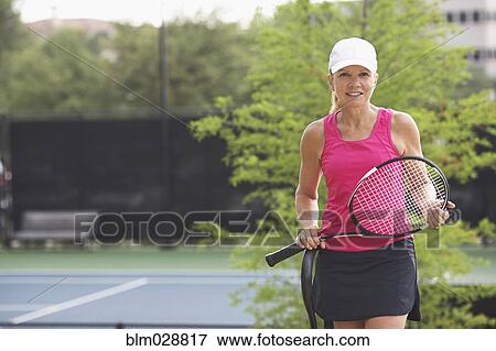 Stock Photo - Caucasian tennis player standing on court. Fotosearch