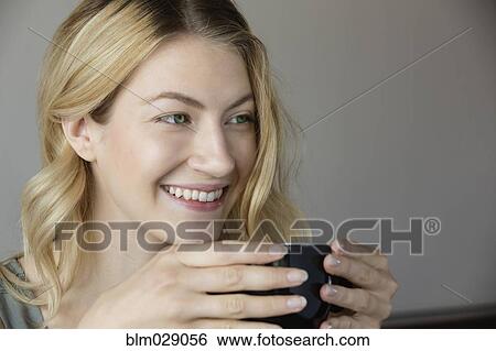 Stock Photograph - Caucasian woman drinking cup of coffee. Fotosearch