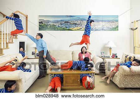Stock Photo - Chinese parents watching son climb all over house. Fotosearch