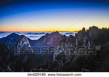 Clouds rolling over rocky mountains, Huangshan, Anhui, China View Large Photo Image Stock Photo - Clouds rolling over rocky mountains, Huangshan, Anhui, China. Fotosearch