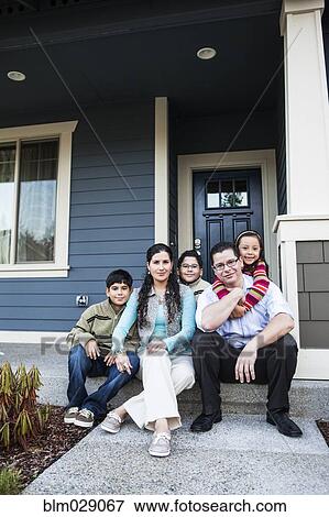 Stock Photo - Family smiling on front stoop. Fotosearch