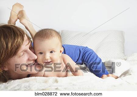 Stock Image - Father and baby laying on blanket. Fotosearch
