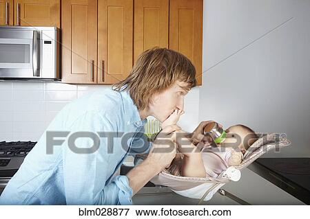 Father kissing baby's feet in chair View Large Photo Image Stock Photo - Father kissing baby's feet in chair. Fotosearch