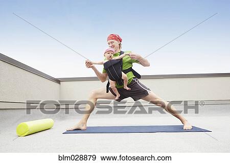Stock Photo - Father practicing yoga and holding baby. Fotosearch