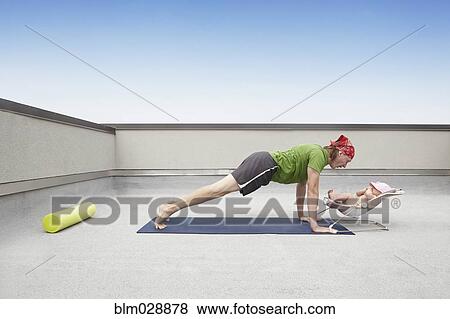 Stock Photo - Father practicing yoga and talking to baby. Fotosearch