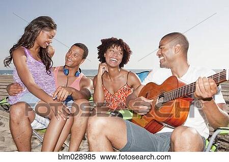 Friends relaxing together on beach View Large Photo Image Stock Photography - Friends relaxing together on beach. Fotosearch