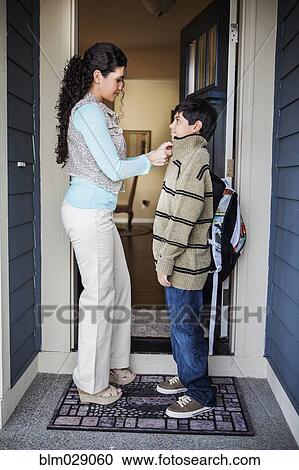 Hispanic mother zipping son's jacket at door View Large Photo Image Stock Image - Hispanic mother zipping son's jacket at door. Fotosearch