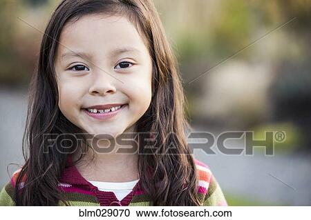 Stock Image - Mixed race girl smiling outdoors. Fotosearch