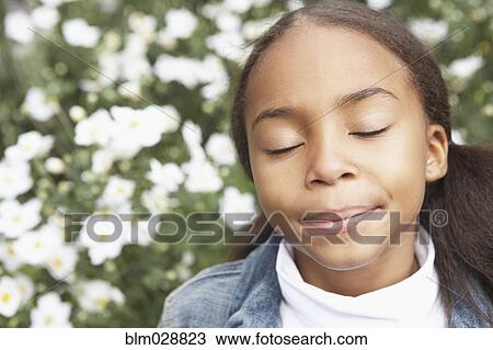 Stock Image - Mixed race girl with eyes closed. Fotosearch