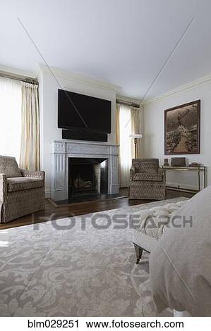 Stock Image - Television and armchairs in ornate bedroom. Fotosearch