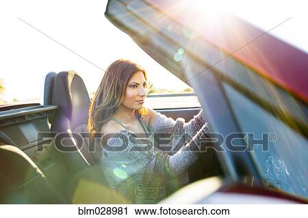 Woman driving convertible at sunset View Large Photo Image Stock Image - Woman driving convertible at sunset. Fotosearch