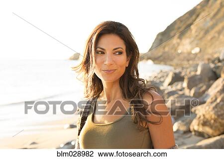 Stock Image - Woman standing on beach. Fotosearch