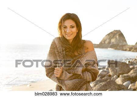 Woman wrapped in sweater on beach View Large Photo Image Stock Image - Woman wrapped in sweater on beach. Fotosearch