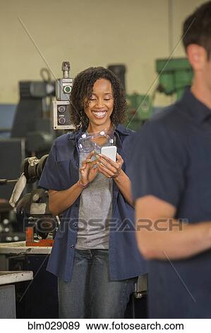 Worker using cell phone in warehouse View Large Photo Image Stock Photo - Worker using cell phone in warehouse. Fotosearch