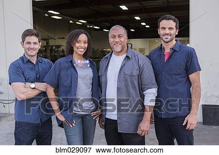 Stock Photo - Workers smiling outside warehouse. Fotosearch