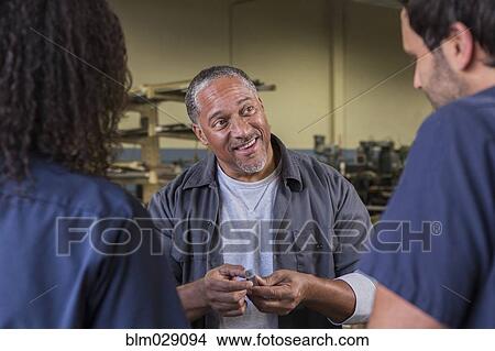 Workers talking in warehouse View Large Photo Image Picture - Workers talking in warehouse. Fotosearch