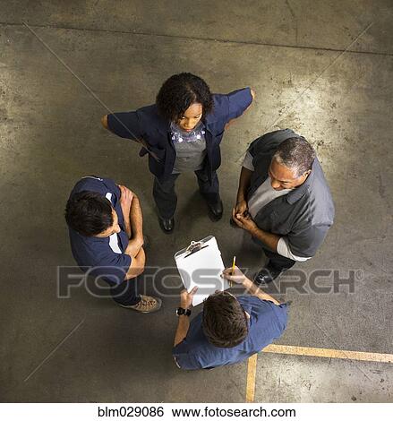 Stock Photograph - Workers talking in warehouse. Fotosearch