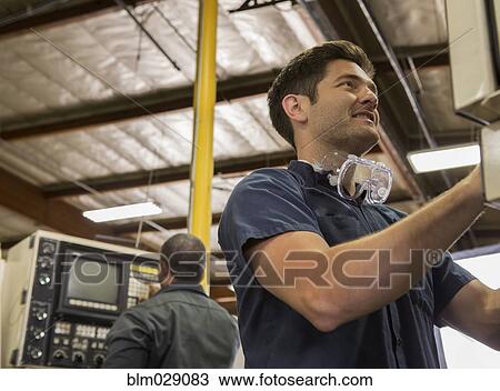 Workers using machinery in warehouse View Large Photo Image Stock Image - Workers using machinery in warehouse. Fotosearch