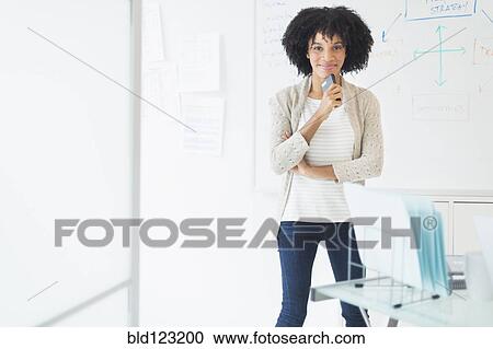 Stock Image - African American businesswoman smiling in office. Fotosearch