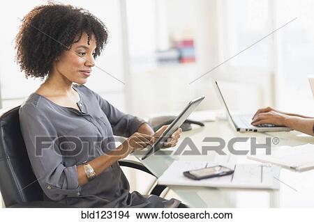 Picture - African American businesswoman using digital tablet. Fotosearch