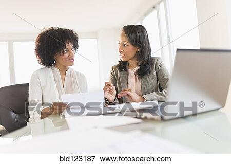 Stock Photo - African American businesswomen talking in meeting. Fotosearch