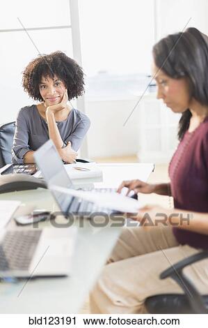 Stock Image - African American businesswomen working in office. Fotosearch