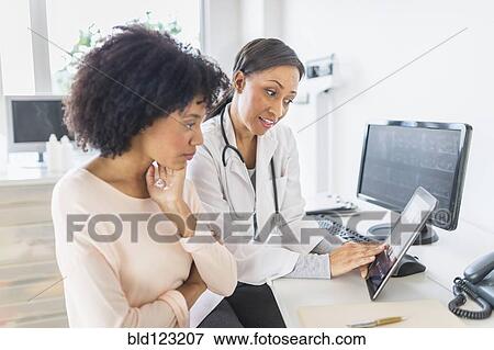 Stock Photo - African American doctor and patient talking in office. Fotosearch