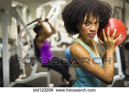 African American woman holding medicine ball in gym View Large Photo Image Stock Photograph - African American woman holding medicine ball in gym. Fotosearch