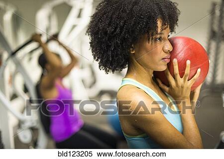 African American woman holding medicine ball in gym View Large Photo Image Stock Photography - African American woman holding medicine ball in gym. Fotosearch