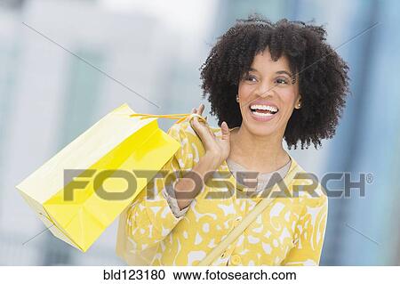 Stock Image - African American woman with shopping bag. Fotosearch