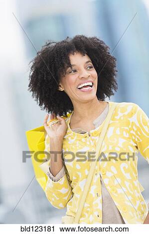 Stock Image - African American woman with shopping bag. Fotosearch