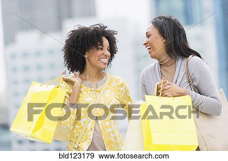 Stock Photo - African American women shopping on city street. Fotosearch