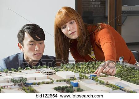 Picture - Business people examining scale model. Fotosearch
