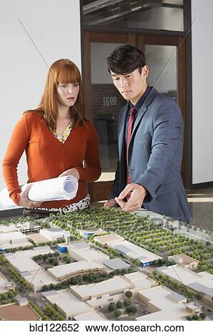Business people examining scale model View Large Photo Image Stock Image - Business people examining scale model. Fotosearch