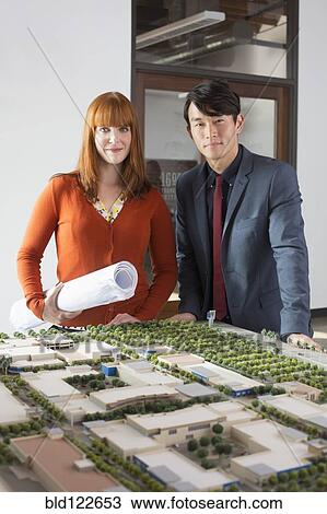 Business people examining scale model View Large Photo Image Stock Image - Business people examining scale model. Fotosearch