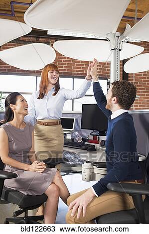 Business people high fiving in office View Large Photo Image Stock Image - Business people high fiving in office. Fotosearch