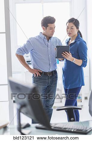 Business people using digital tablet in office View Large Photo Image Stock Image - Business people using digital tablet in office. Fotosearch