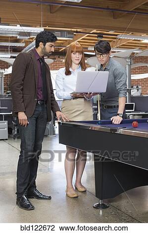 Business people using laptop in office lounge area View Large Photo Image Stock Image - Business people using laptop in office lounge area. Fotosearch