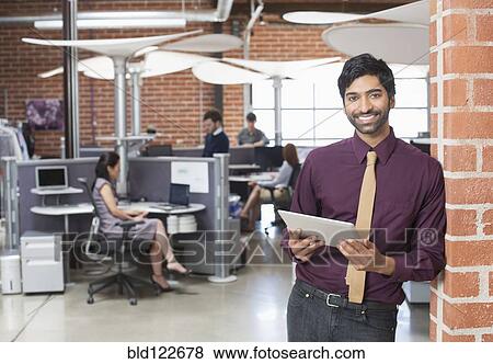 Businessman holding digital tablet in office View Large Photo Image Stock Photo - Businessman holding digital tablet in office. Fotosearch