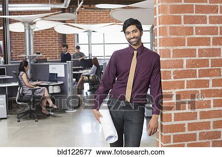 Businessman smiling in office View Large Photo Image Stock Photo - Businessman smiling in office. Fotosearch